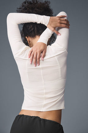Back view of a woman wearing a ribbed Sea Coast long sleeve shirt, showcasing its soft fabric and slim fit.