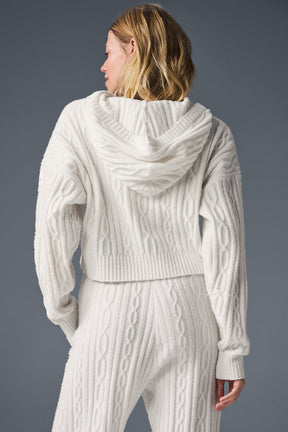 Back view of a woman wearing a cozy Cable Knit Winter Bliss Hoodie with a relaxed fit and cropped hem.