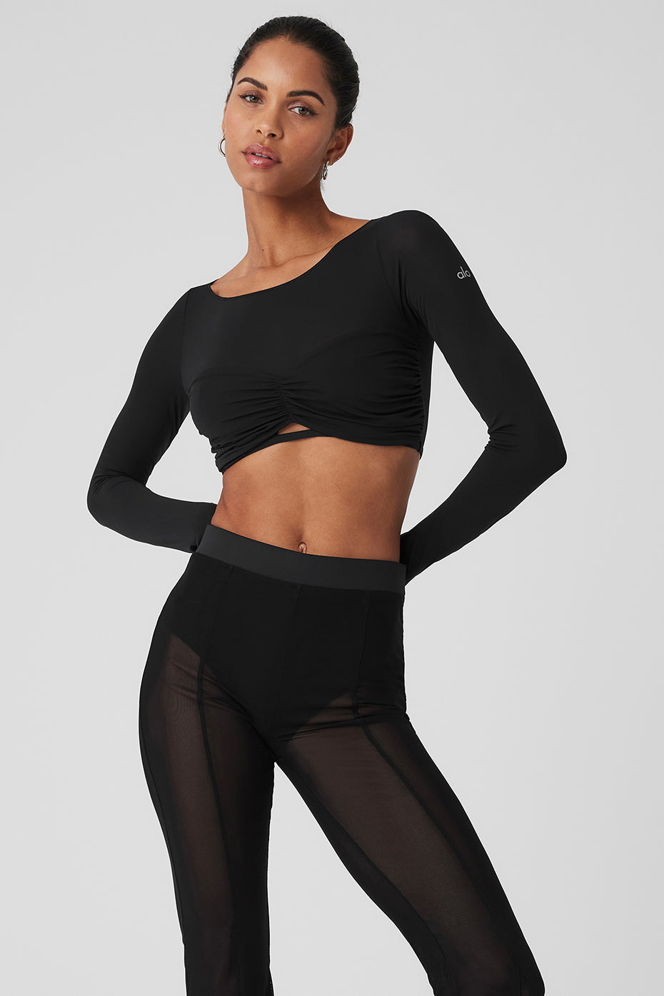 Model wearing a Mesh Sheer Illusion cropped long sleeve top with gathered front and boat neck paired with high-rise pants.