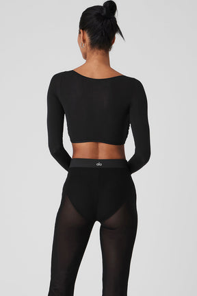 Model wearing a Mesh Sheer Illusion cropped long sleeve top and high-waisted black mesh pants from the back.