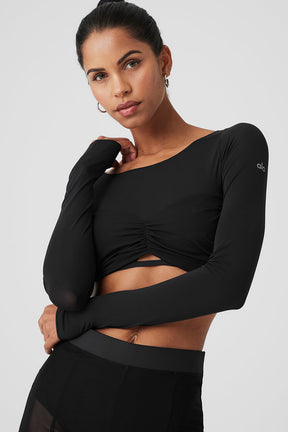 Model wearing Mesh Sheer Illusion Cropped Long Sleeve top with boat neck and gathered front detail.