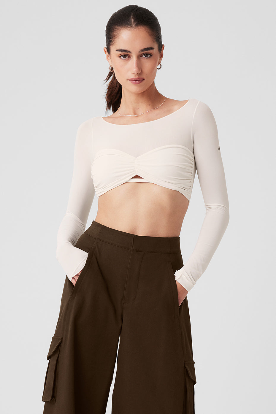 Model wearing Mesh Sheer Illusion Cropped Long Sleeve top with gathered front and keyhole cutout styled with high-waisted pants.