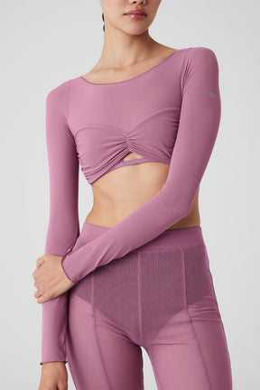 Mesh sheer illusion cropped long sleeve top in soft pink with gathered front and boat neck design.