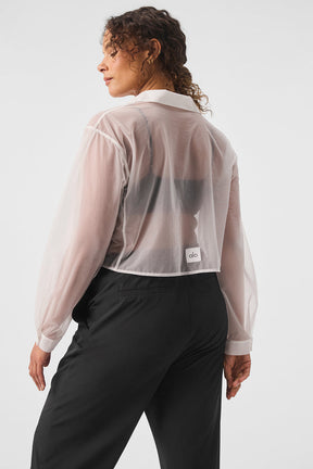 Model wearing sheer cropped Take Me Out button-up shirt with point collar and cuffs styled with black trousers.