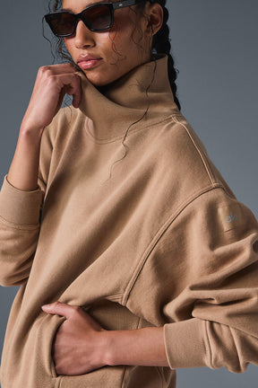 Woman wearing soft, cozy hazy mock neck pullover sweater with oversized fit and sunglasses.