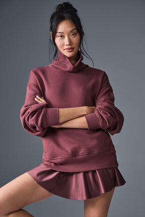 Model wearing Hazy Mock Neck Pullover in burgundy, showcasing its oversized fit and cozy style.