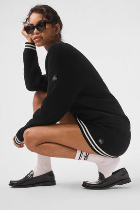 Model wearing Tennis Club Sweater Knit Cardigan with dropped shoulders, ribbed cuffs, and classic striped trim.