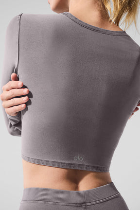Back view of a woman wearing a Washed Alosoft Crop Finesse Long Sleeve in grey, featuring a chic cropped design.