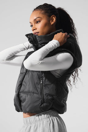 Model wearing a cozy-luxe Gold Rush Puffer Vest with a high collar, showcasing its cinched design and zip pockets.