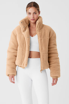 Sherpa Snow Angel Puffer in beige, featuring a tall collar and zippered pockets for warmth and style.