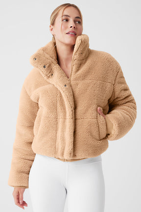 Sherpa Snow Angel Puffer in tan color featuring a tall collar and zippered pockets for warmth on cold days.