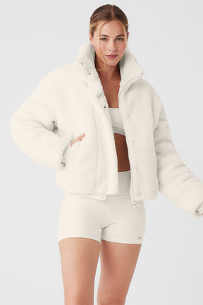 Model wearing white Sherpa Snow Angel Puffer jacket with tall collar, zippered pockets, and snug fit for warmth.