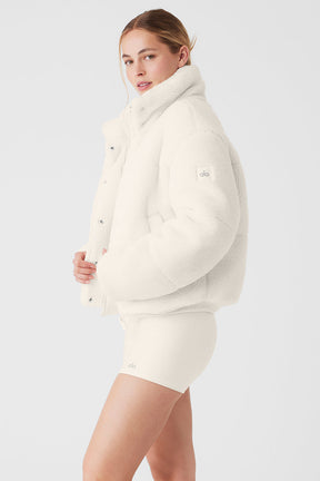 Sherpa Snow Angel Puffer jacket in white, featuring a tall collar and zippered pockets for warmth during outings.