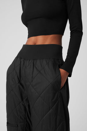Close-up of high-waist snowrider puffer pant featuring quilted finish and wide ribbed waistband.