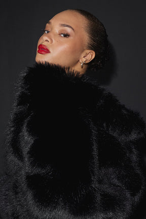 Model showcasing an opulent faux fur cropped jacket with a stand collar and elegant styling.