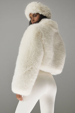 Opulent faux fur cropped jacket with a stand collar and boxy shape, styled with matching hat, showcasing chic elegance.