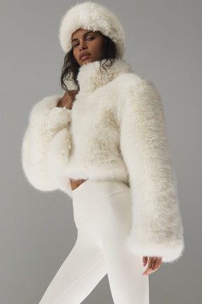 Opulent faux fur cropped jacket in white worn with matching hat; chic, elegant, and ultra-fluffy design.