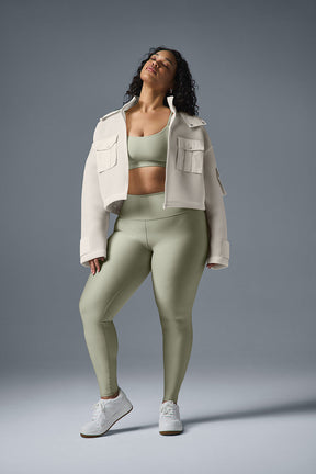 Model wearing a cropped cargo parka over a matching set, showcasing a stylish sporty look with baggy jeans and sneakers.