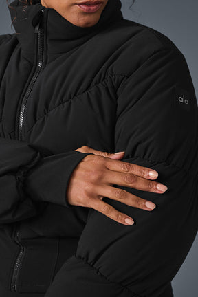 Close-up of a model wearing a black Main Act Corset Puffer jacket showcasing the cropped silhouette and puffy sleeves.