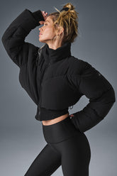 A model showcasing the Main Act Corset Puffer jacket with a cropped silhouette and corset hemline.