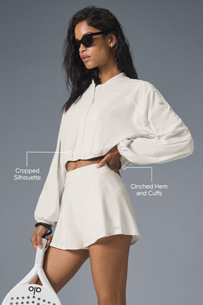 Model wearing Tiebreaker Jacket with cropped silhouette and cinched cuffs, paired with matching skirt, ideal for sports and casual wear.