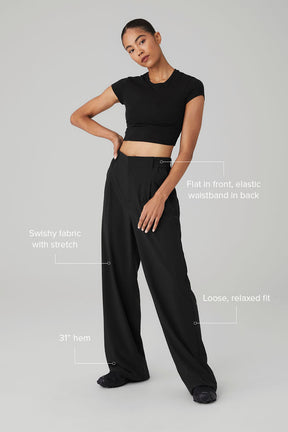Model showcasing high-waist pursuit trousers with relaxed fit and stretchy, lightweight fabric.