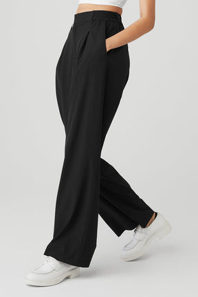 High-waist pursuit trouser with relaxed wide-leg fit, pleats, and stretchy waistband in black.