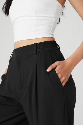 High-waist pursuit trouser featuring a stretchy waistband and relaxed wide-leg fit, styled with a fitted top.