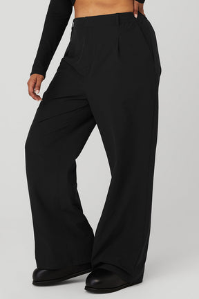 High-waist pursuit trouser in black with relaxed wide-leg fit and classic pleats for stylish comfort.