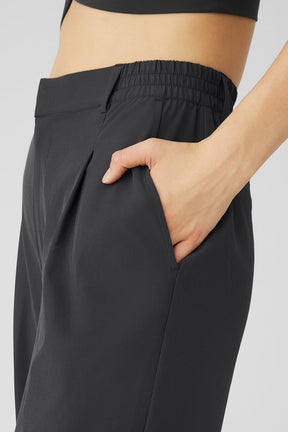 High-waist pursuit trouser featuring a relaxed fit, pleats, and an elastic waistband with pockets.