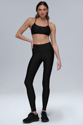 Model wearing Airlift Winter Warm High-Waist Legging with matching bra in black, showcasing second-skin fit and high waist.