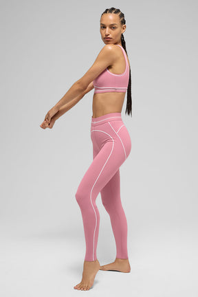 Model wearing Airbrush High-Waist Heart Throb Legging in pink with matching bra, showcasing contouring contrast stitching.