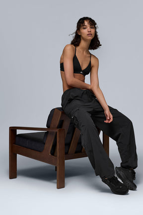 Model wearing Megastar Cargo Pants with a cropped black tank, showcasing modern baggy fit and adjustable features.