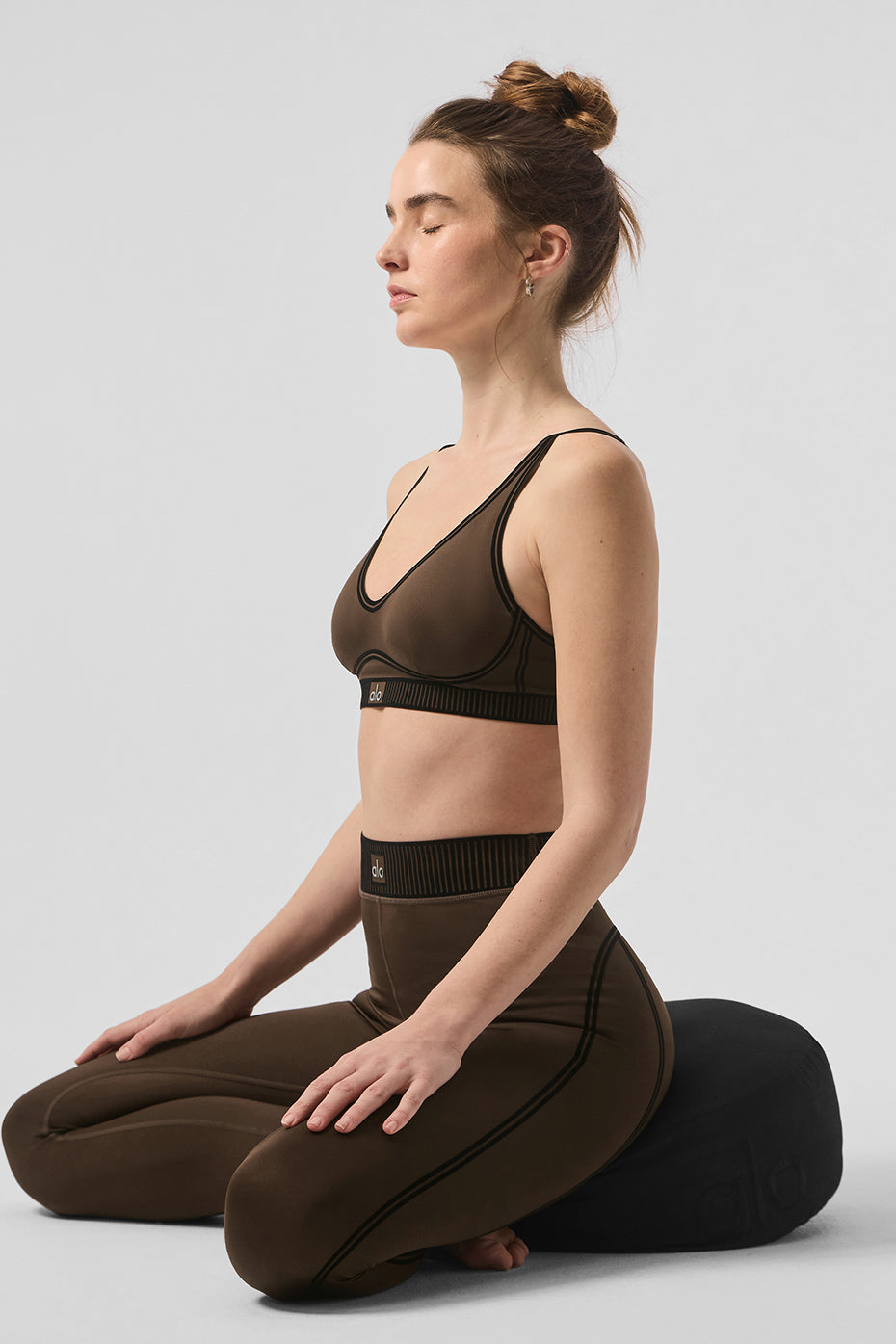 Woman meditating in Airlift High-Waist 7/8 Line Up Legging and matching sports bra, showcasing versatile activewear.