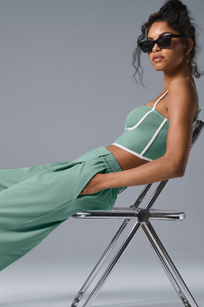 Model wearing high-waist pursuit trousers in green, showcasing relaxed fit and stylish details.