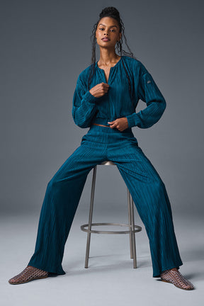 High-waist micro plisse straight leg pant styled with a matching top, featuring relaxed fit and crinkly texture.