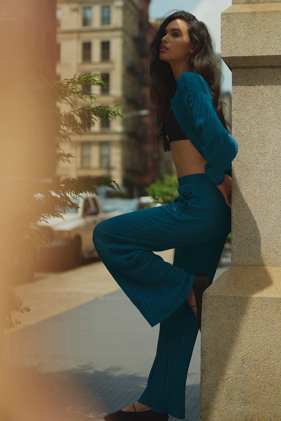Model wearing high-waist micro plisse straight leg pant with relaxed fit in urban setting.