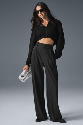 Model wearing High-Waist Dreamscape Trousers styled with a cropped black zip-up top and sunglasses.