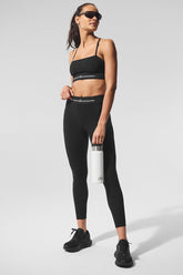 Model wearing Alosoft High-Waist 7/8 Relay Legging and Relay Bra, accessorized with sunglasses and a water bottle.