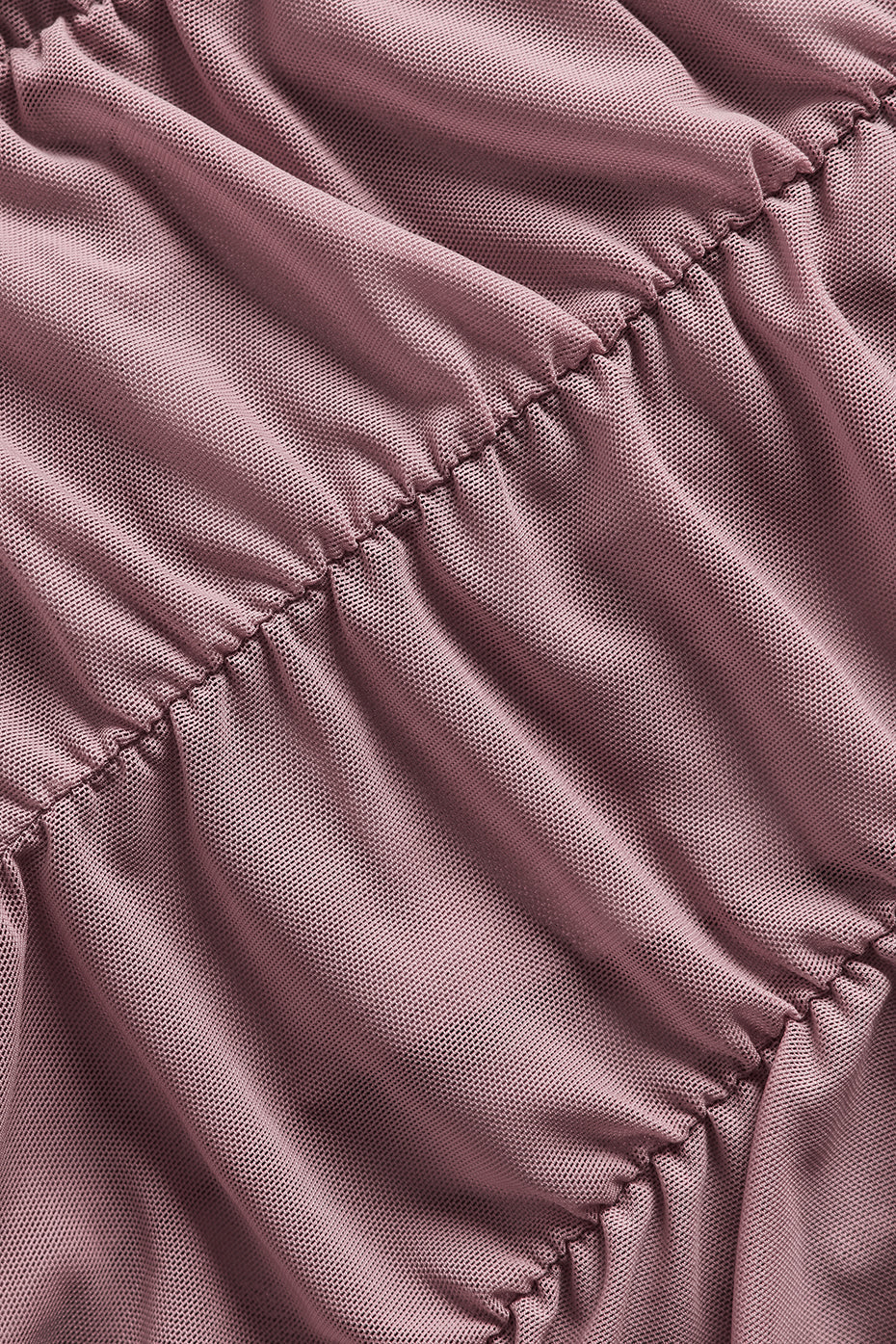 Close-up view of Airlift Mesh High-Waist Cherish Legging fabric, showcasing its ruched texture in a soft pink hue.