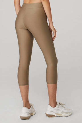 Model wearing Airlift High-Waist Conceal-Zip Capri in brown, showcasing flattering fit and hidden zip pocket.