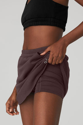 Model showcasing the High-Waist Accolade Skirt with internal shorts and side pockets in a stylish pose.