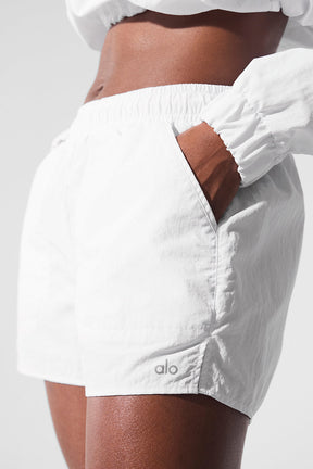 Close-up of high-waist Alumni Short in white, featuring side pockets and lightweight fabric for comfort and style.