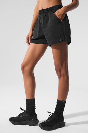 Model wearing black Alumni Short with high-waist design and side pockets, perfect for hiking and exploring.