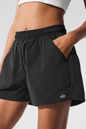 Alumni Short in black with high-waist design, side pockets, and elastic drawcord for active lifestyles.