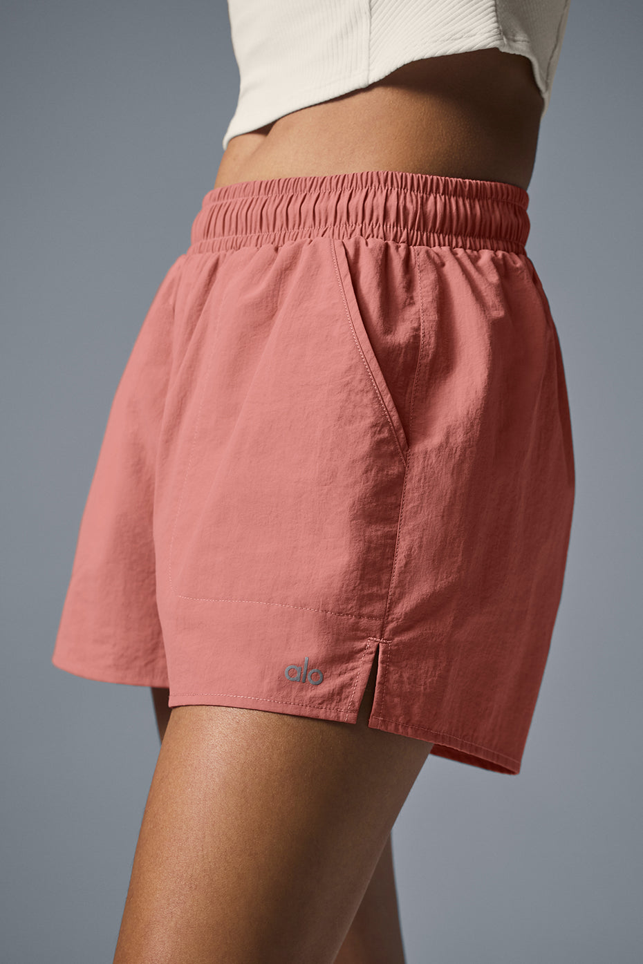 Alumni Short in coral with high waist, internal drawcord, and side pockets for hiking and exploring.