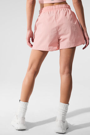 Back view of a model wearing pink Alumni Short, featuring a high-waist design and sporty fabric for active exploration.
