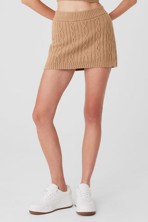 Cable knit winter bliss mini skirt in cozy tan with elastic waistband, worn with white sneakers.