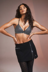 Model showcasing a Winter Wool Vendome Mini Skirt paired with a stylish top, highlighting its A-line silhouette and functional zippers.