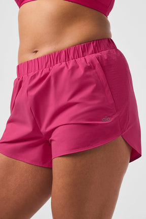 Playmaker Dolphin Shorts featuring elastic waist, side pockets, and stylish design in bright pink color.